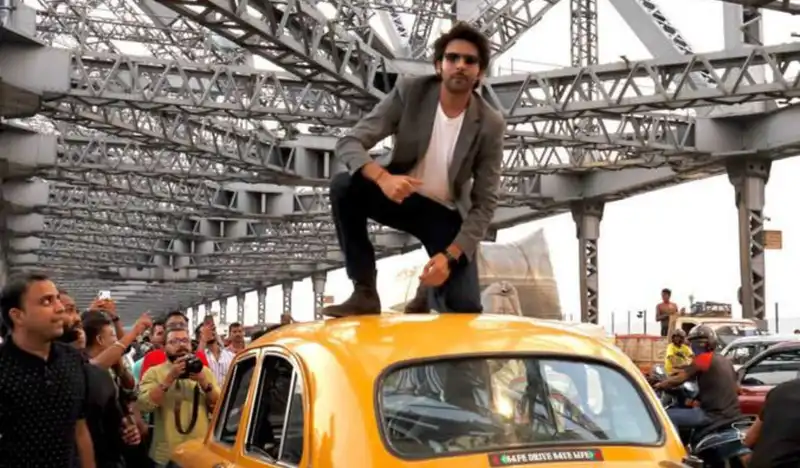 Bhool Bhulaiyaa 2: Kartik Aaryan climbs on top of a yellow taxi as he greets fans at Kolkata’s Howrah Bridge